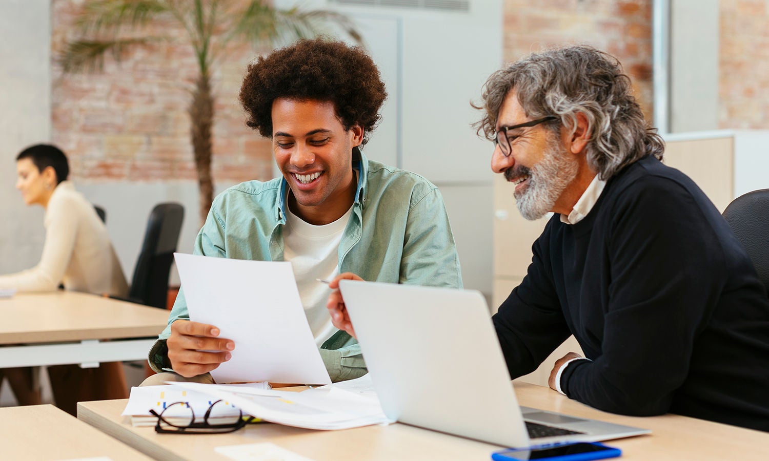 A group of people of varying age and ethnicity sitting at a desk